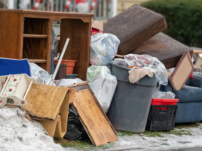 Furniture and household junk staged at the curb for pickup