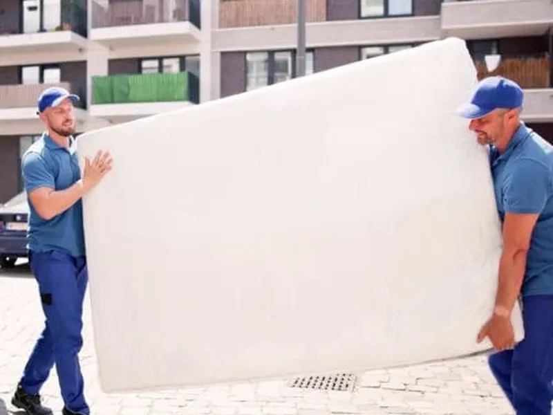 A mattress being carried out of a home by a Freedom Junk Removal crew member