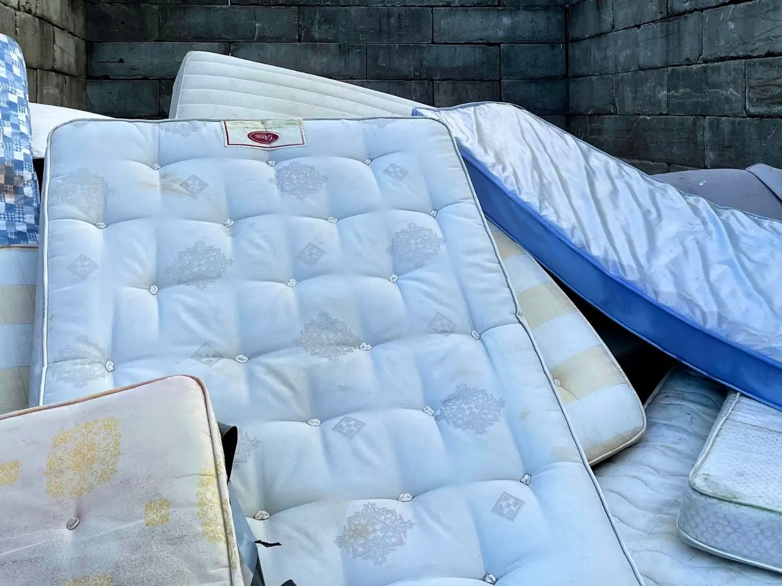 A stack of mattresses staged for pickup